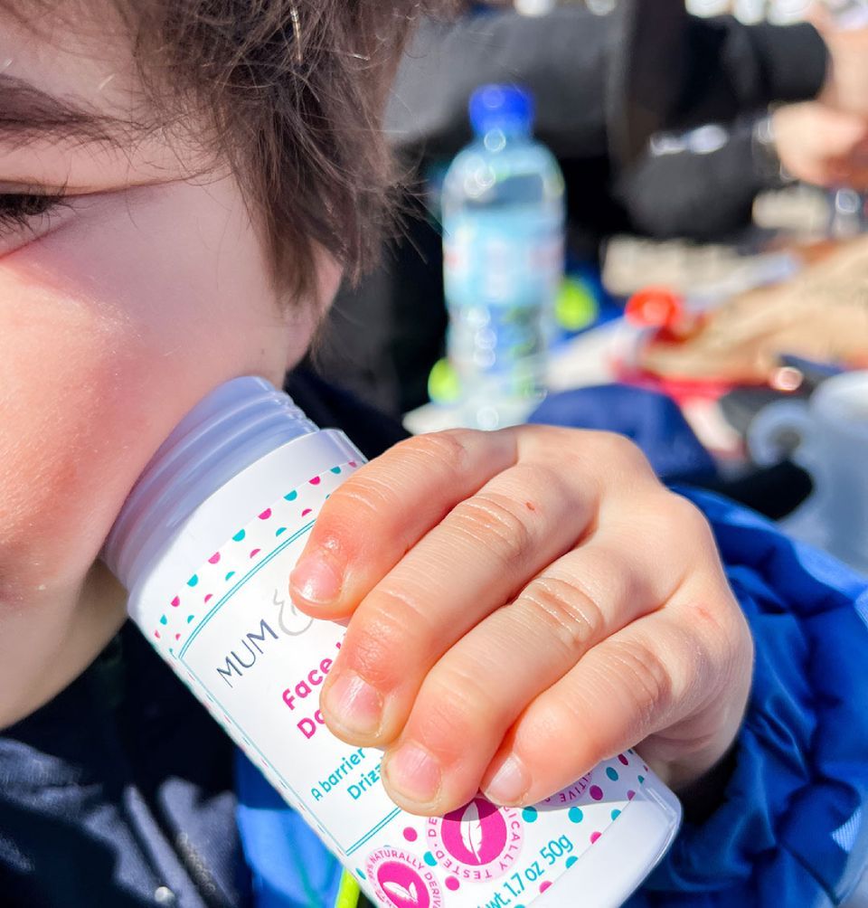 A young boy holds a water bottle, showcasing hydration and the importance of protecting delicate skin from the elements.